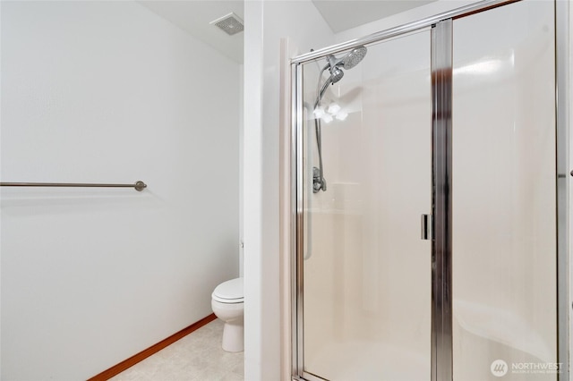 bathroom featuring toilet, a shower stall, visible vents, and baseboards