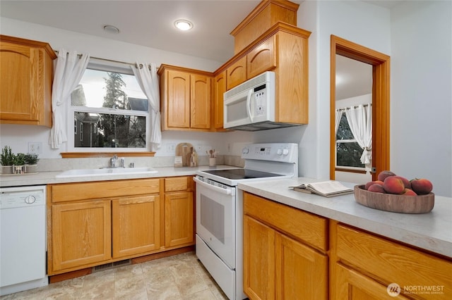 kitchen with white appliances, visible vents, light countertops, and a sink