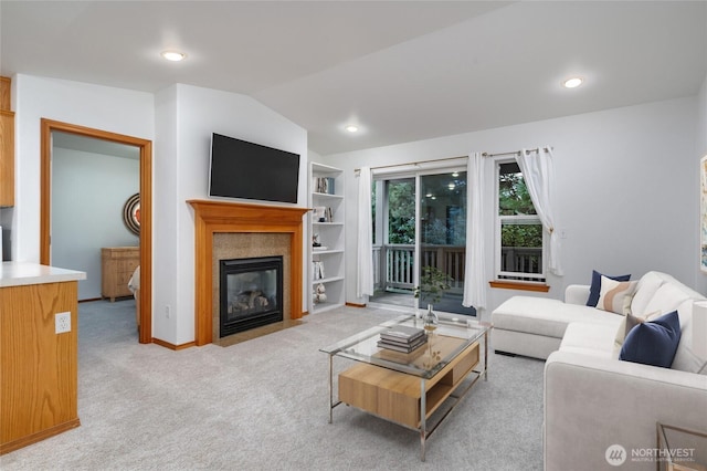 living room with built in features, light colored carpet, a fireplace with flush hearth, vaulted ceiling, and recessed lighting