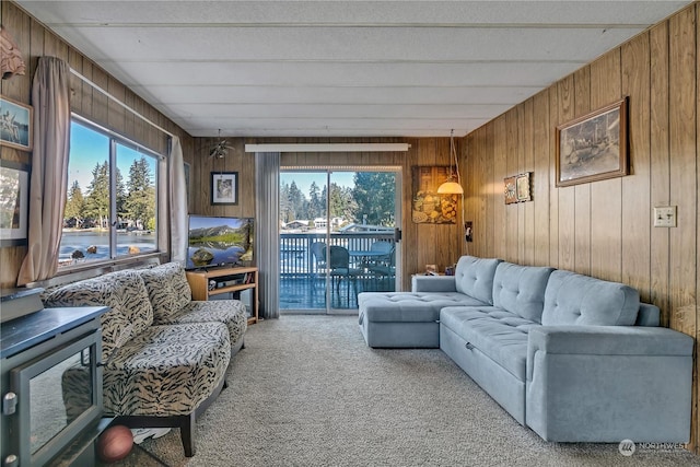 living room featuring light carpet and wood walls