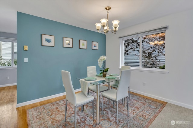 dining room featuring baseboards, a chandelier, and wood finished floors