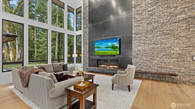 living room featuring light wood-type flooring and a towering ceiling