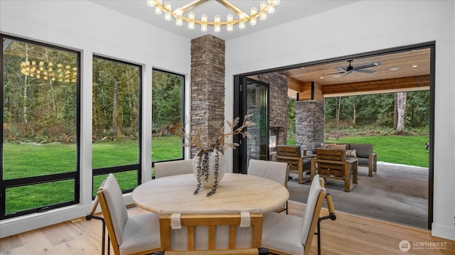 sunroom / solarium with ceiling fan with notable chandelier