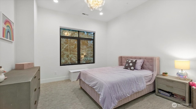 bedroom with an inviting chandelier and light colored carpet