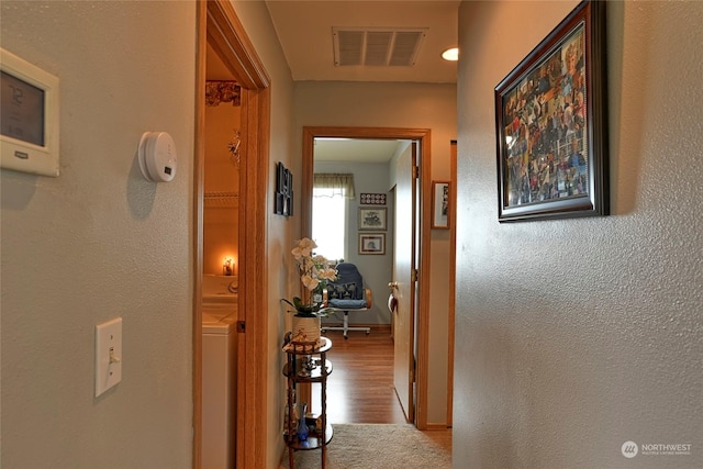 hallway featuring washer / clothes dryer and hardwood / wood-style flooring