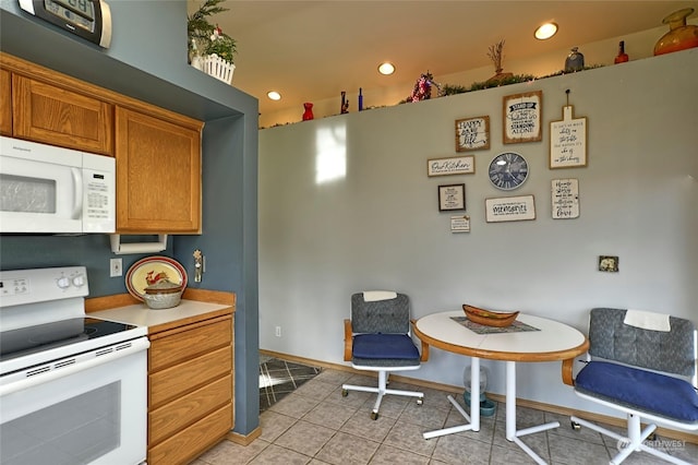 kitchen featuring light tile patterned flooring and white appliances