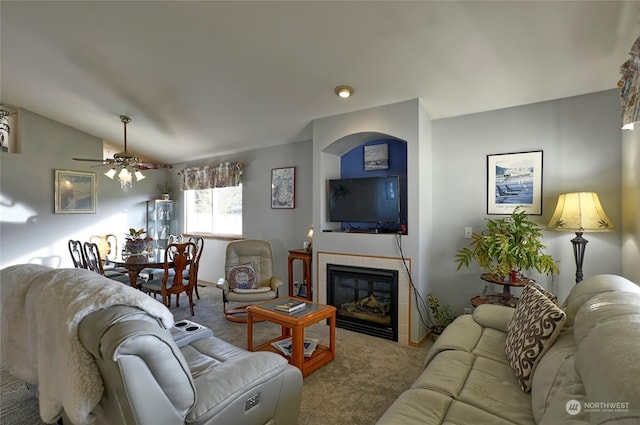 living room featuring ceiling fan, lofted ceiling, a fireplace, and carpet floors