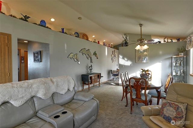 carpeted living room with ceiling fan and vaulted ceiling