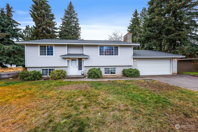 split foyer home featuring a garage and a front yard