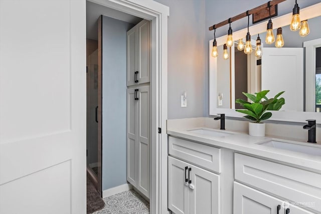 full bathroom featuring double vanity, a shower stall, a closet, and a sink