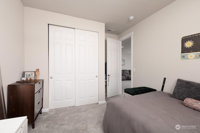 bedroom with light colored carpet and a closet