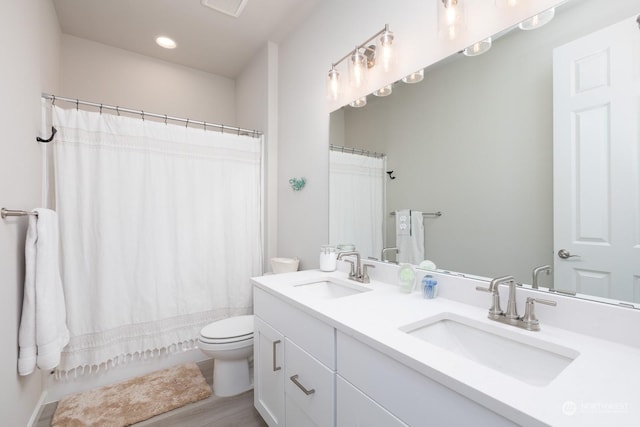 full bathroom with shower / bath combination with curtain, vanity, and toilet