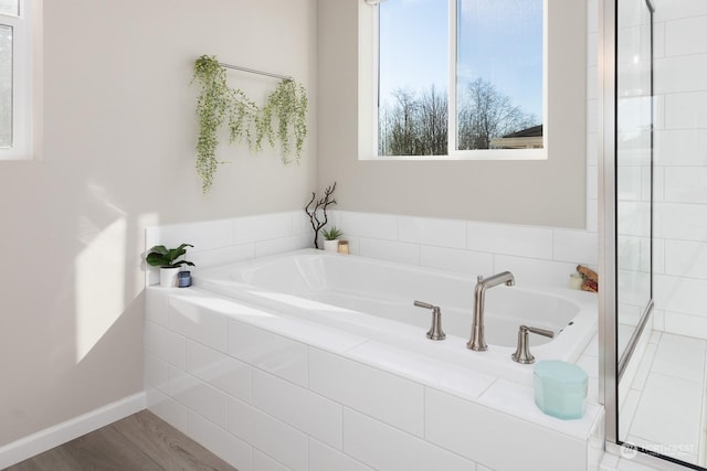 bathroom featuring wood-type flooring and tiled tub