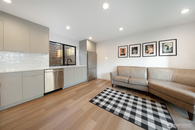 living room with light hardwood / wood-style floors and sink