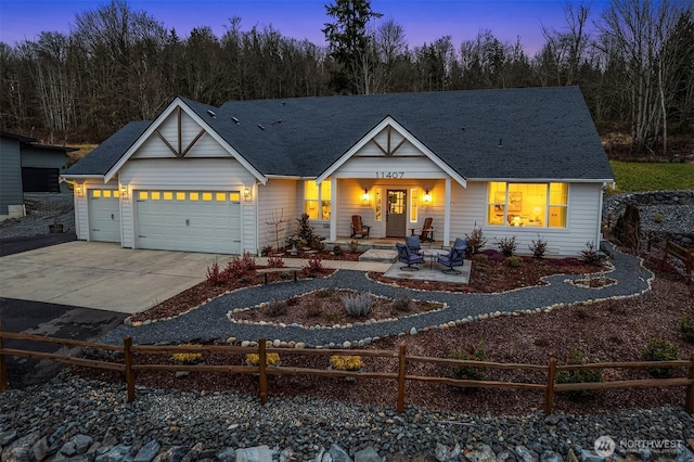 view of front of property with a garage, concrete driveway, a shingled roof, and fence