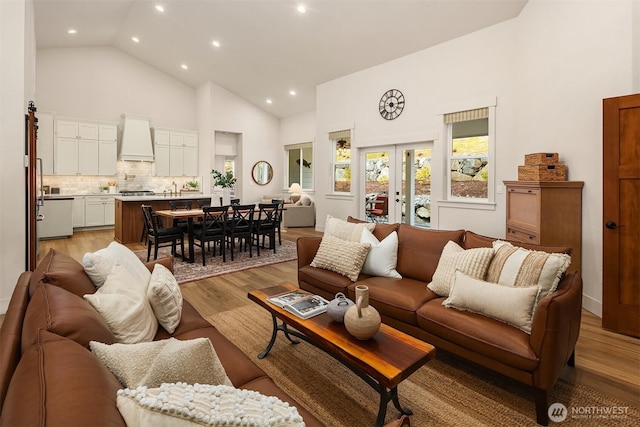 living area featuring high vaulted ceiling, light wood finished floors, french doors, and recessed lighting