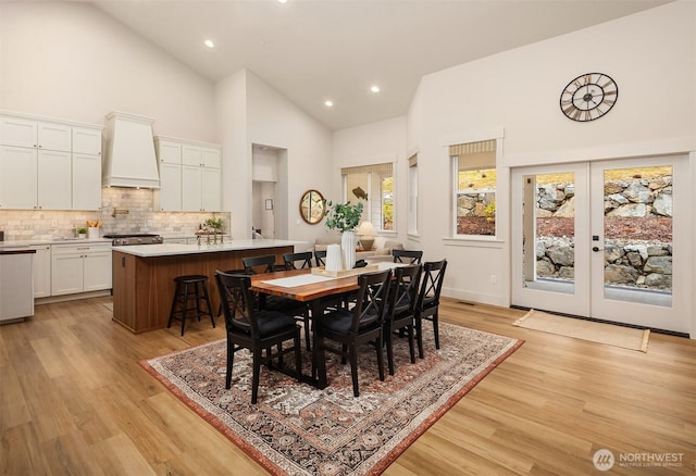 dining space with high vaulted ceiling, french doors, light wood-style flooring, and recessed lighting