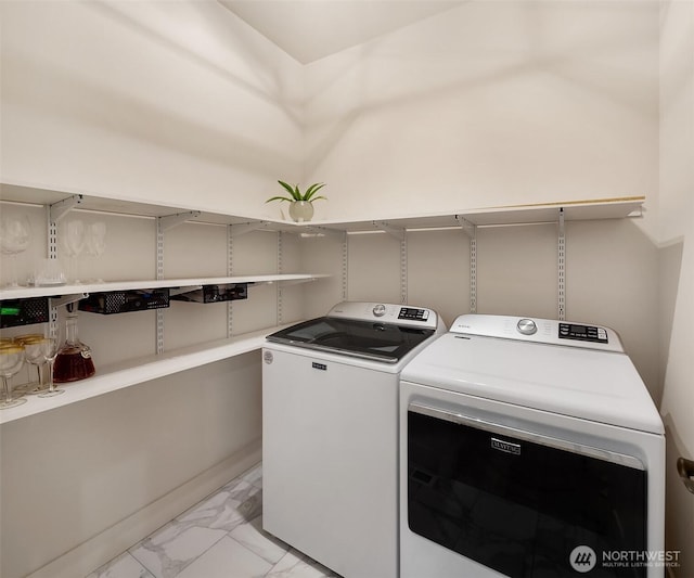 laundry area featuring laundry area, marble finish floor, and washing machine and clothes dryer