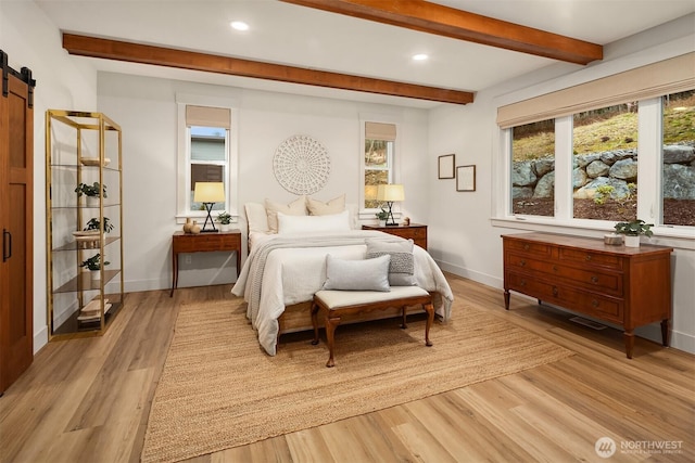 bedroom featuring a barn door, baseboards, beamed ceiling, light wood-style floors, and recessed lighting