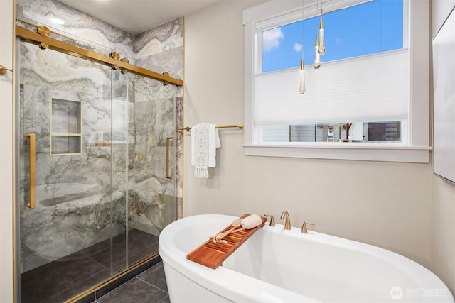 bathroom with a stall shower, tile patterned flooring, and a freestanding tub