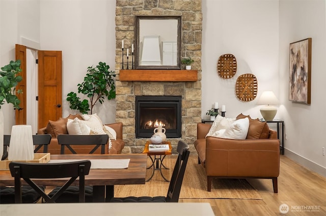 sitting room with light wood-style flooring, a fireplace, and baseboards