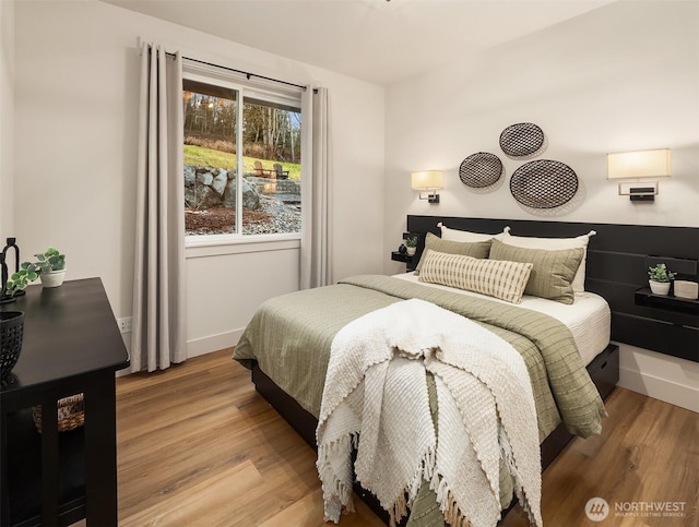 bedroom with light wood-type flooring and baseboards