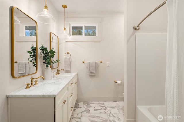 full bath with marble finish floor, a sink, baseboards, and double vanity