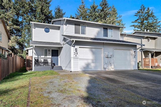 view of property with a garage, a front yard, and covered porch