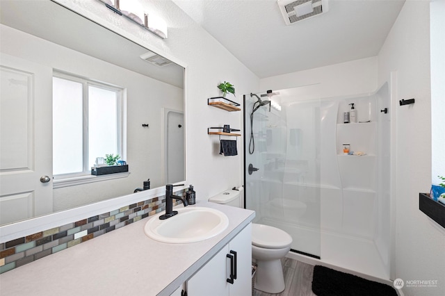 bathroom featuring walk in shower, vanity, toilet, and hardwood / wood-style floors