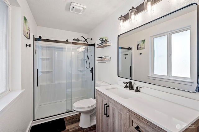 bathroom with vanity, wood-type flooring, toilet, and walk in shower