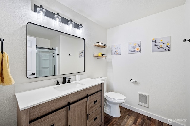 bathroom featuring vanity, toilet, an enclosed shower, and hardwood / wood-style floors