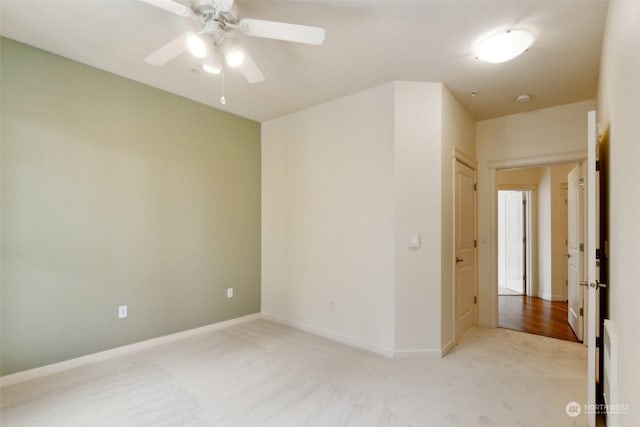 empty room featuring light colored carpet and ceiling fan