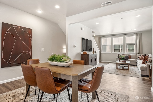 dining area with lofted ceiling and light hardwood / wood-style flooring