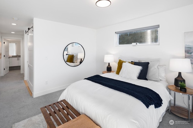 bedroom featuring light colored carpet and a barn door