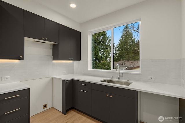 9221D 14th Ave NW, Seattle, WA 98117 - kitchen featuring dark cabinets, backsplash, light wood-style flooring, and recessed lighting