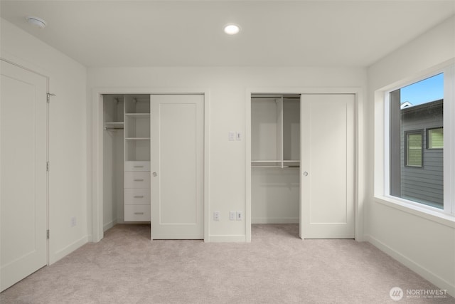 9221D 14th Ave NW, Seattle, WA 98117 - unfurnished bedroom featuring two closets, light colored carpet, and recessed lighting