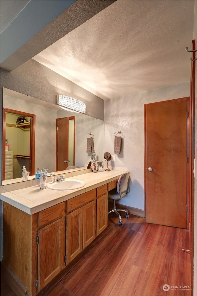 bathroom featuring wood-type flooring, a textured ceiling, and vanity