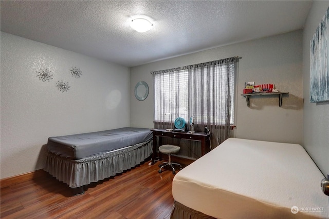 bedroom with dark wood-type flooring and a textured ceiling