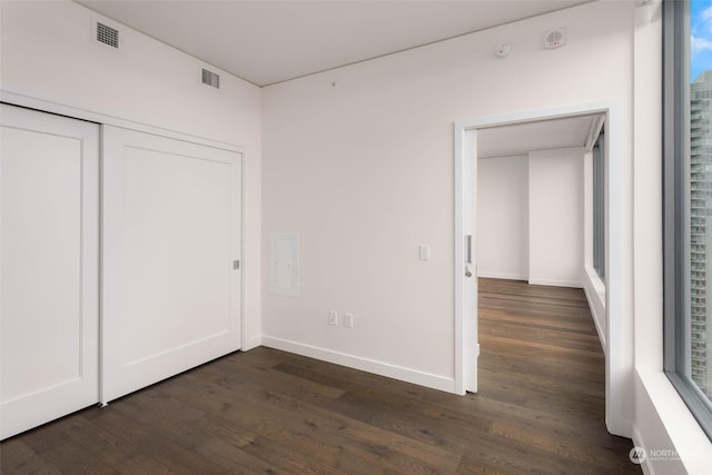 unfurnished bedroom featuring dark hardwood / wood-style floors and a closet