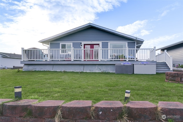 rear view of property with a yard and a deck