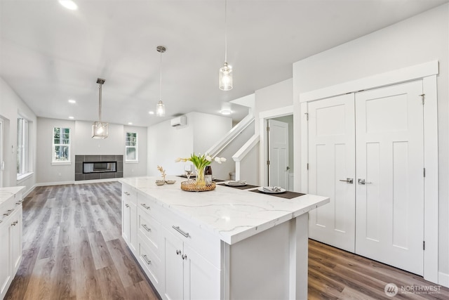 kitchen with hanging light fixtures, white cabinetry, open floor plan, and a center island