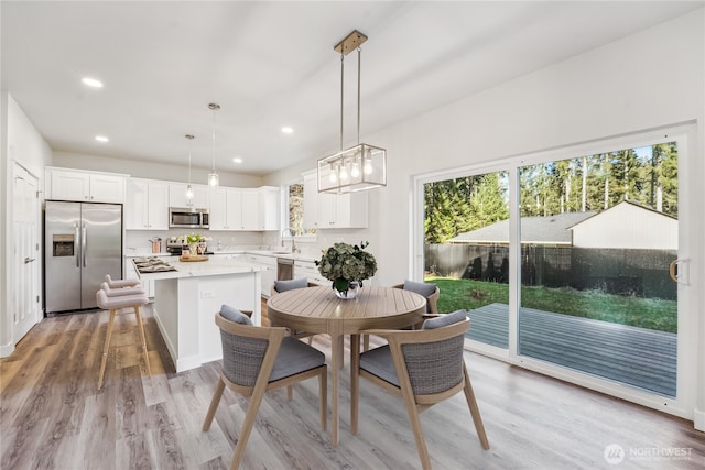 dining space featuring wood finished floors and recessed lighting