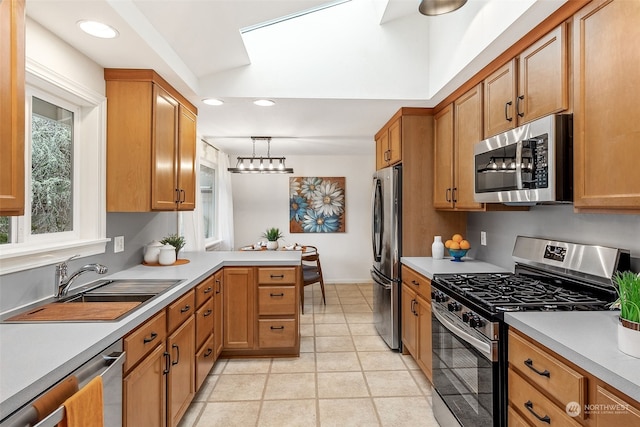 kitchen featuring light tile patterned floors, sink, appliances with stainless steel finishes, hanging light fixtures, and kitchen peninsula