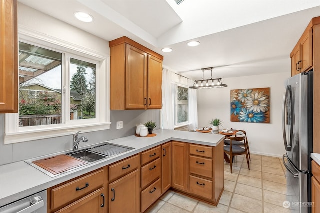 kitchen with appliances with stainless steel finishes, decorative light fixtures, sink, kitchen peninsula, and an inviting chandelier