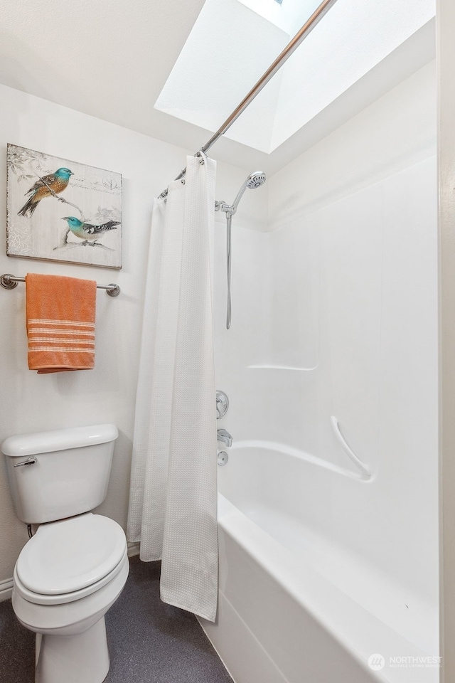 bathroom featuring a skylight, shower / bath combination with curtain, and toilet