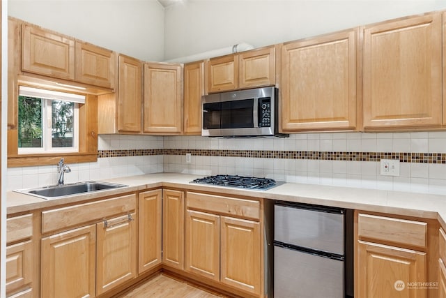 kitchen with tasteful backsplash, sink, stainless steel appliances, and light brown cabinets