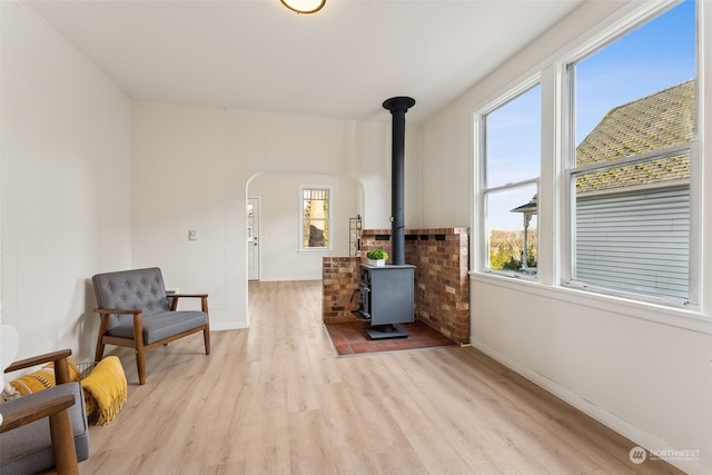 sitting room featuring light wood-type flooring and a wood stove