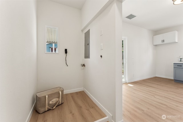 washroom featuring electric panel and light wood-type flooring