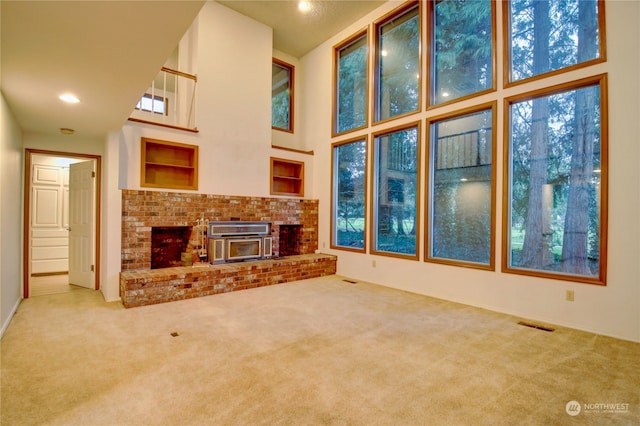 unfurnished living room featuring carpet floors and a high ceiling