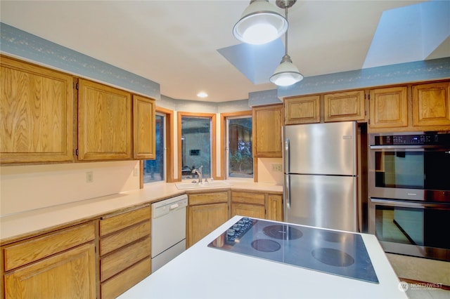 kitchen with sink, decorative light fixtures, and stainless steel appliances